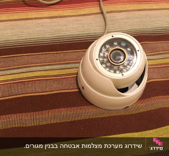 Security camera on a striped surface with cables.
